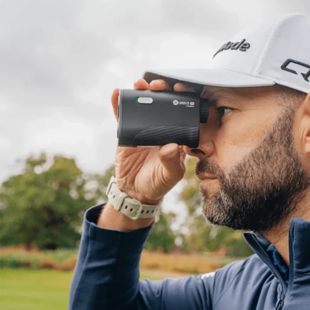 Man using a golf rangefinder on a golf course