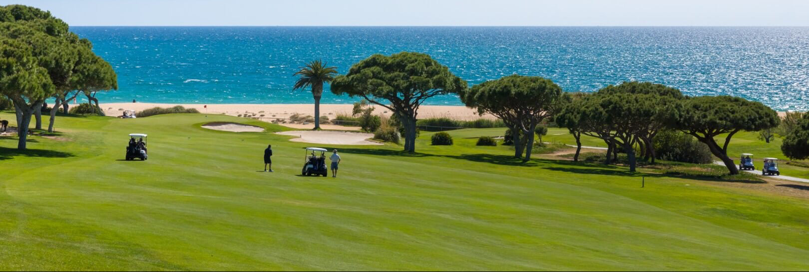 Golf course with ocean view under clear blue sky